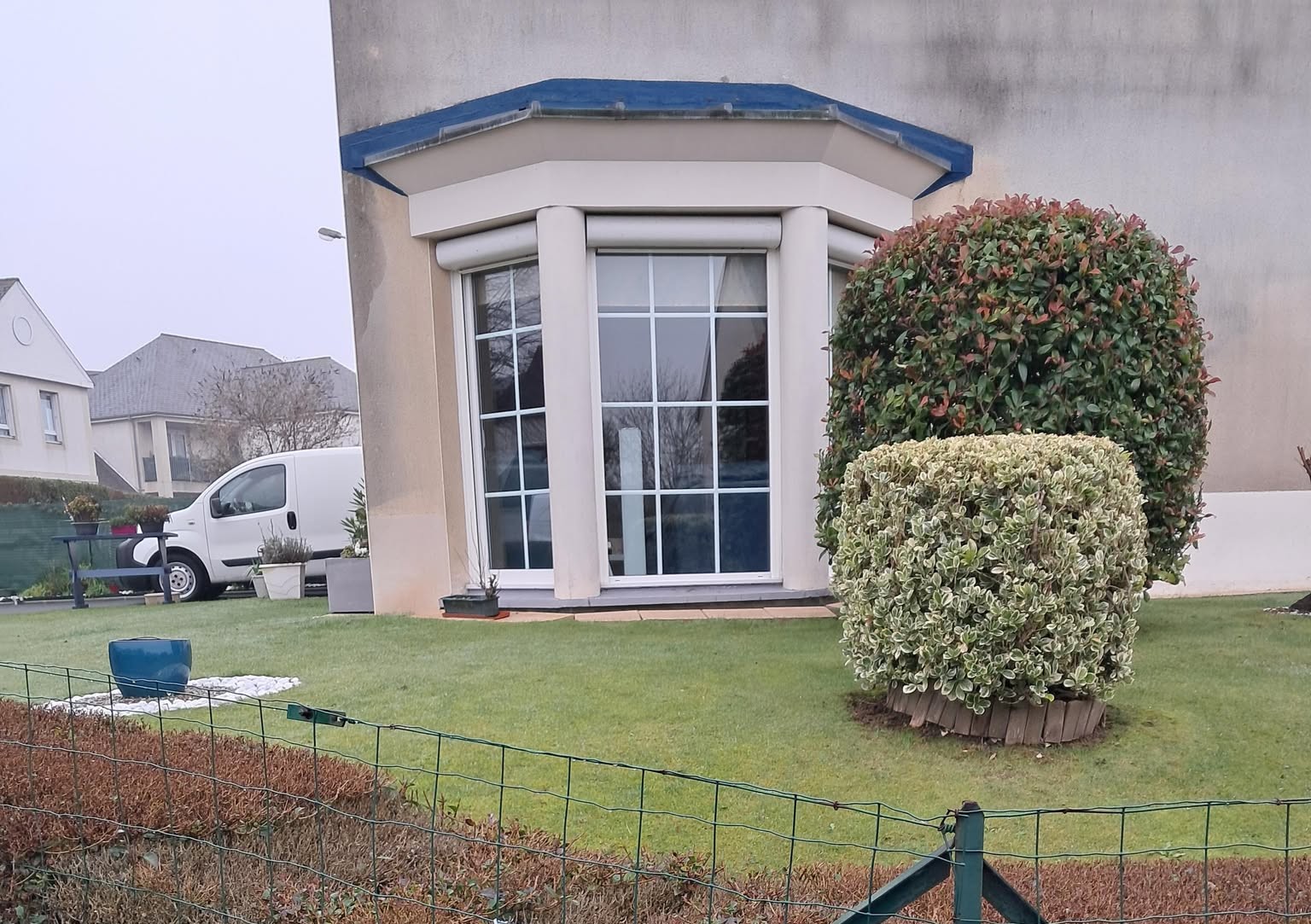 Fenêtre à vitrage multiple, encadrée par des colonnes, avec un auvent en matériau composite.