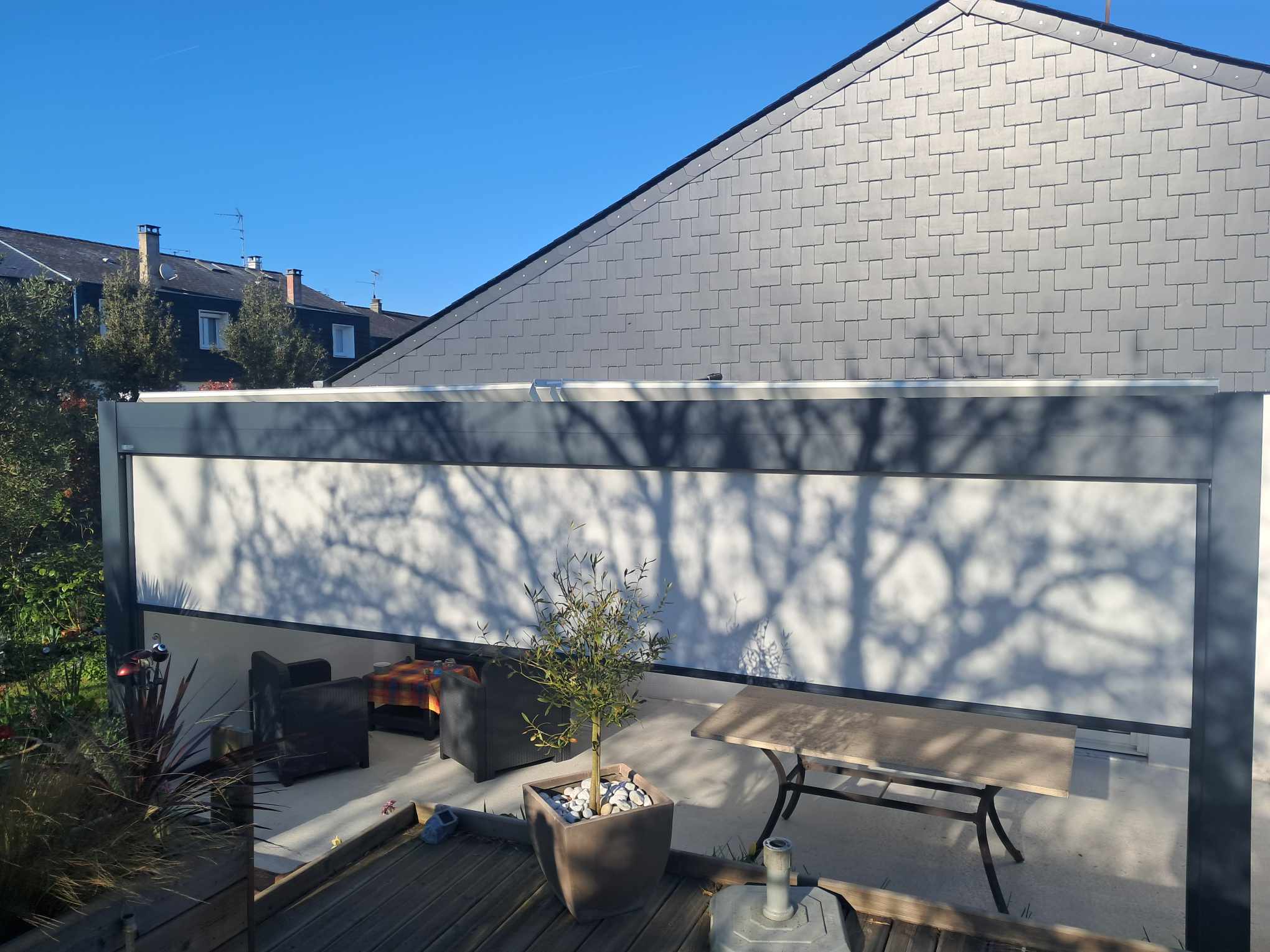 Pergola en aluminium avec stores en toile, offrant une protection contre le soleil.