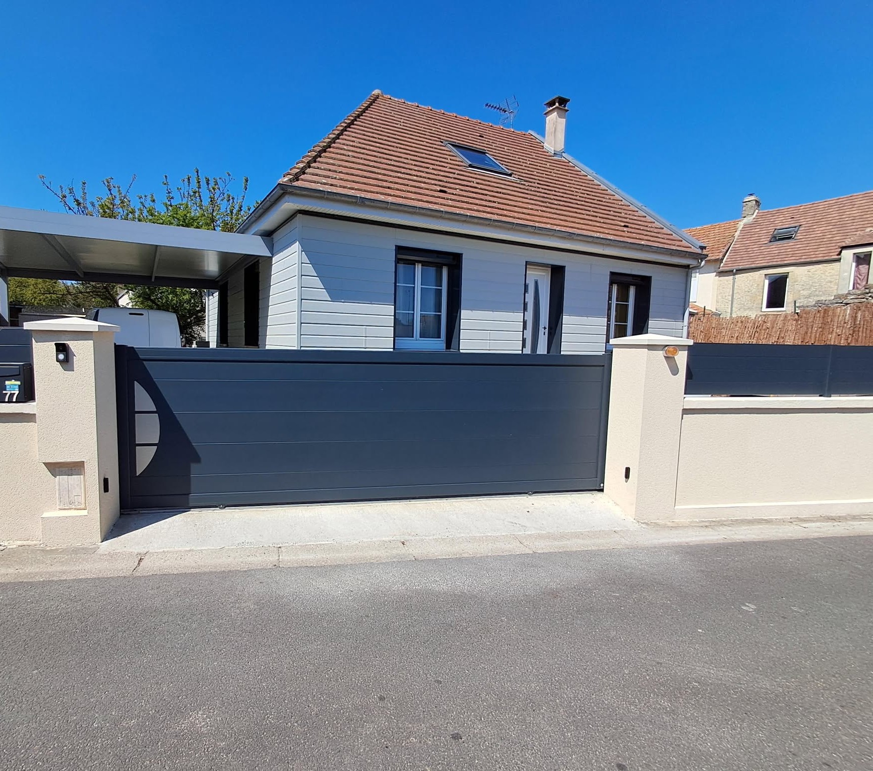 Portail coulissant en aluminium gris.