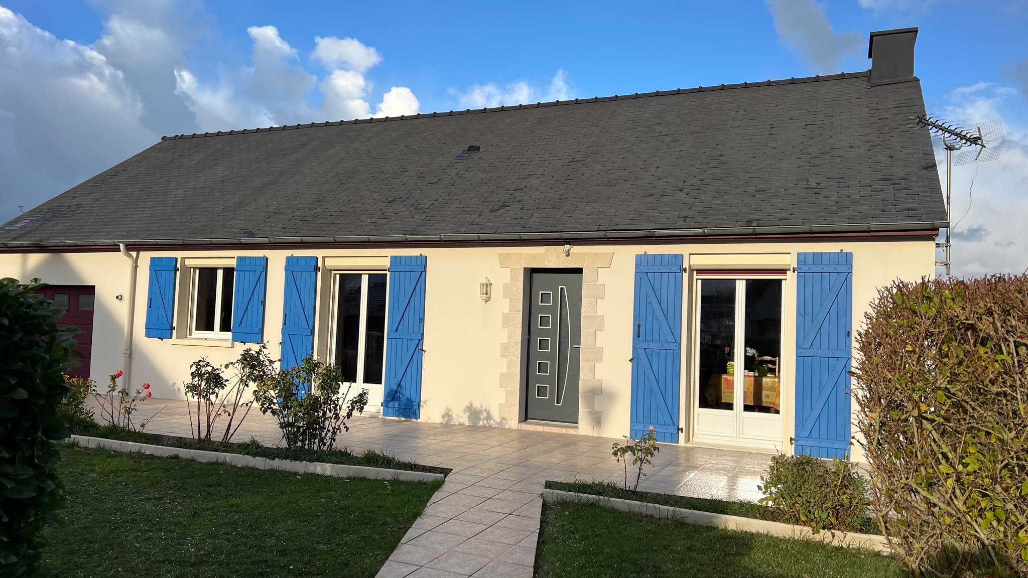 Volet en bois peint en bleu, installé sur une maison.