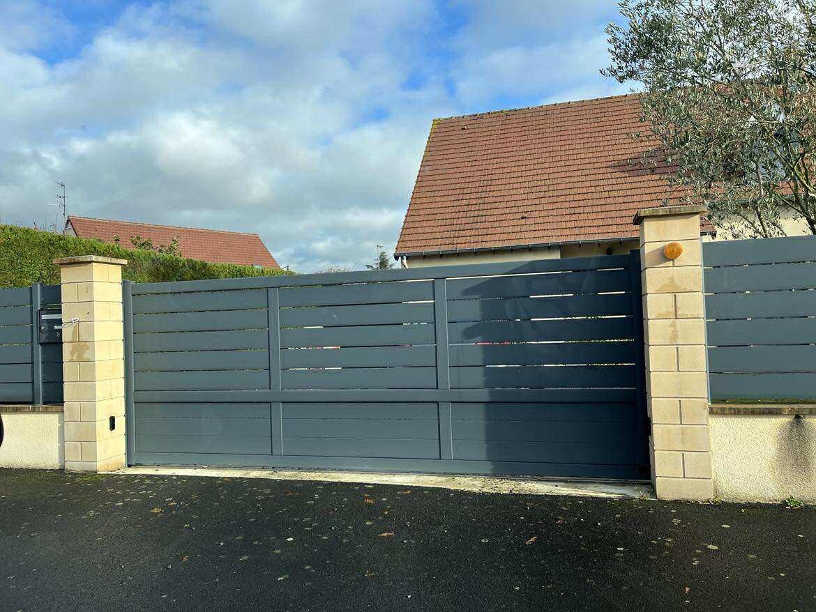 Portail coulissant en aluminium gris avec lames horizontales.