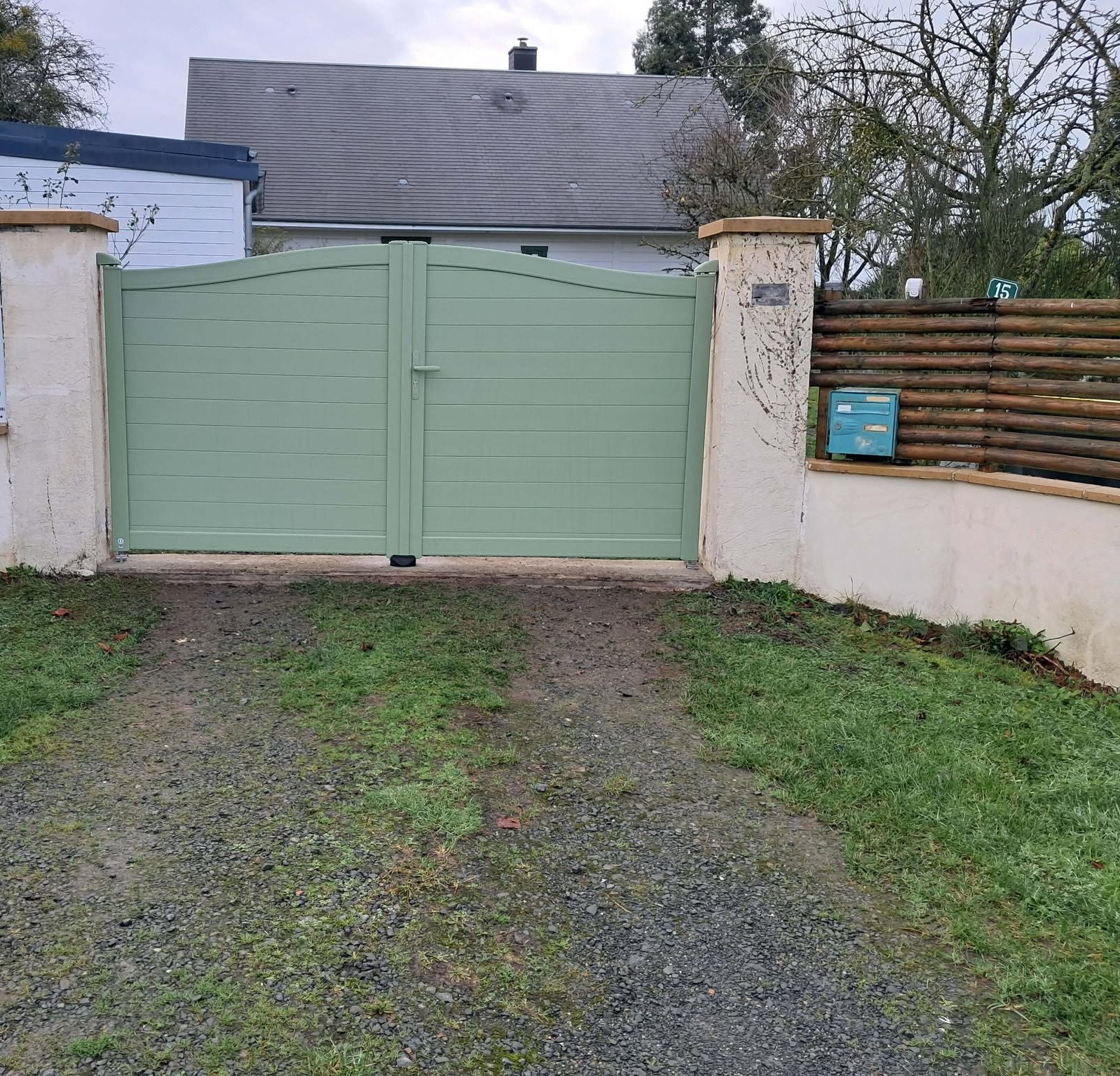 Portail en aluminium vert avec panneaux en bois.