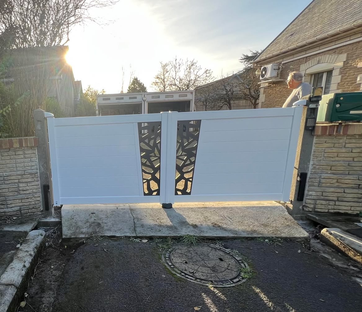 Portail en PVC blanc avec motif décoratif, installé à l'entrée d'une maison.