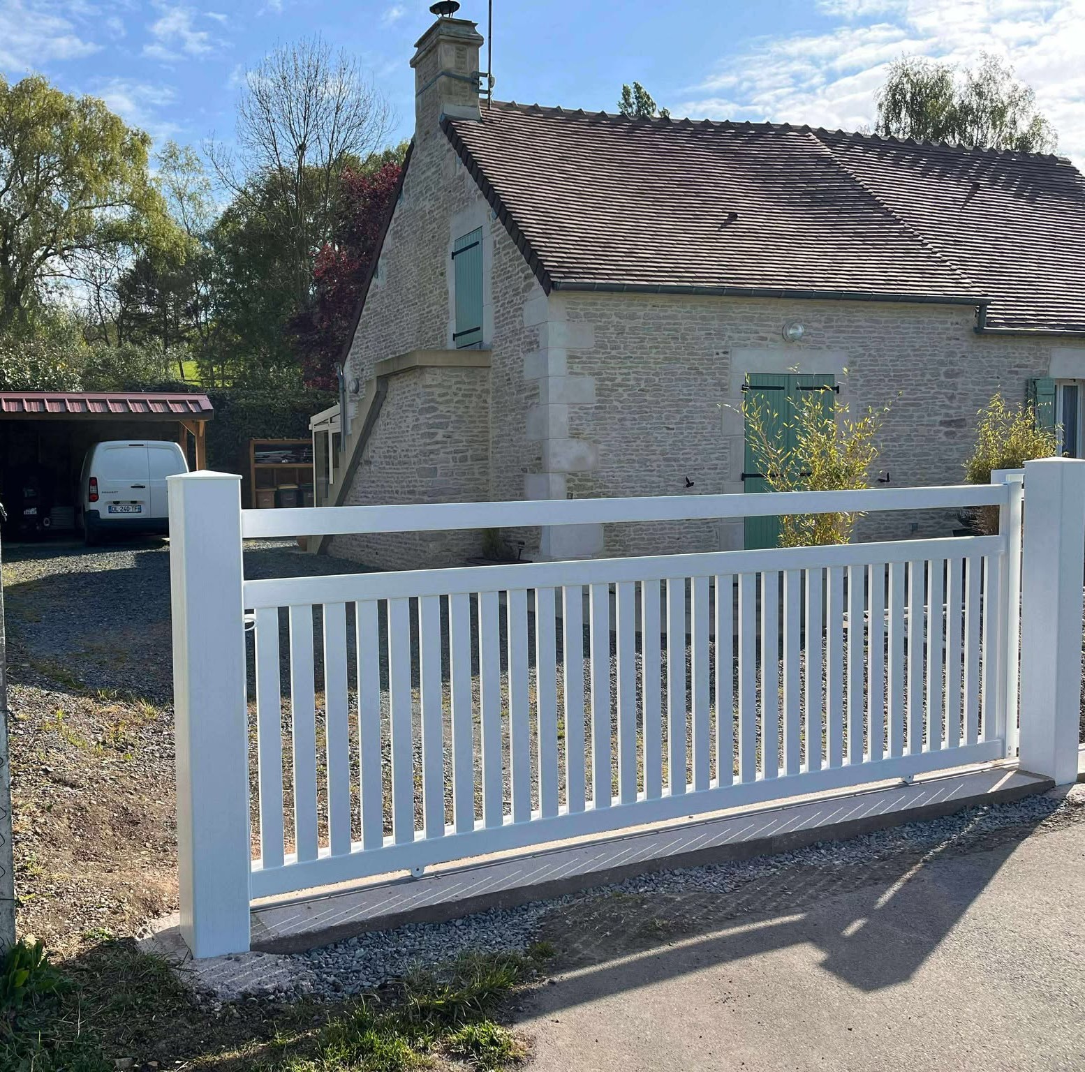 Portail en bois peint en blanc, avec un design à lattes verticales.