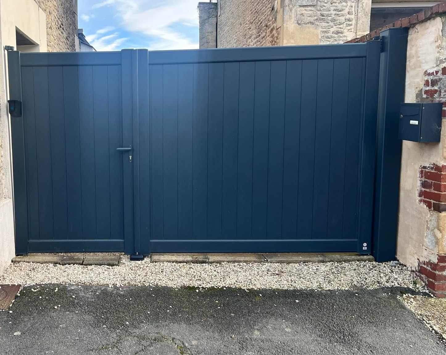 Portail en aluminium noir, deux vantaux avec poignée et système de fermeture.