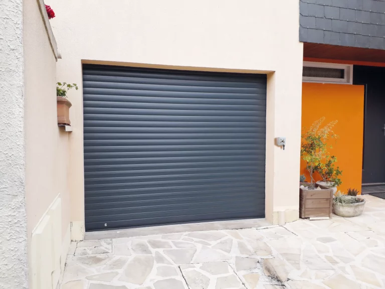 Porte de garage enroulable en métal, de couleur grise.