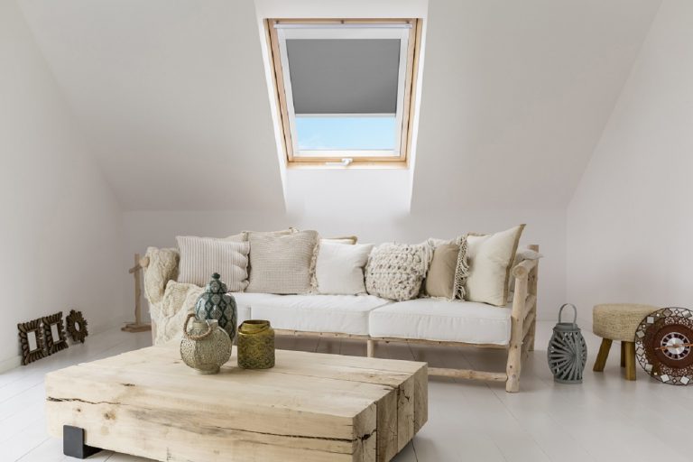 Fenêtre Velux en bois avec store occultant, installée dans un toit en pente.