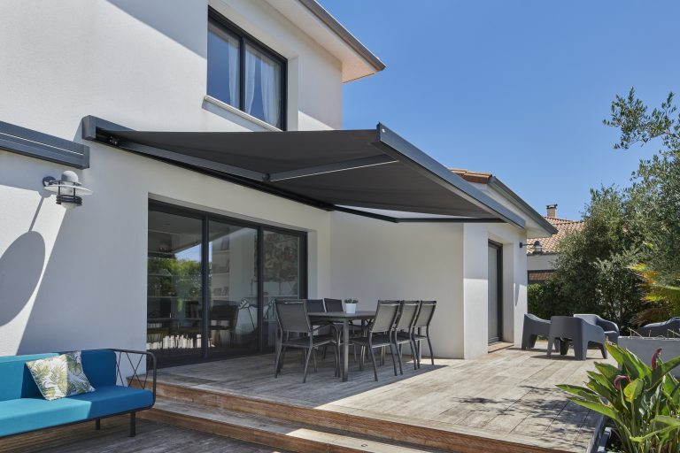 Store extérieur en toile noire installé sur une terrasse en bois.
