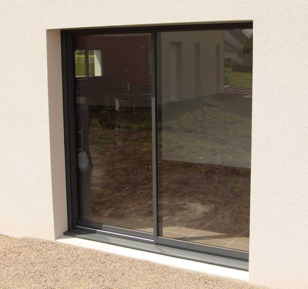 Fenêtre coulissante en aluminium noir avec vitrage.