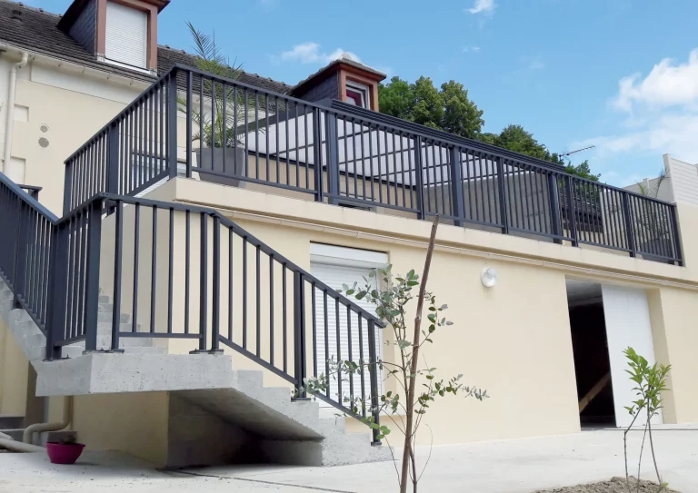 Garde-corps en métal noir, installé sur une terrasse, avec un design contourné et des barres verticales.