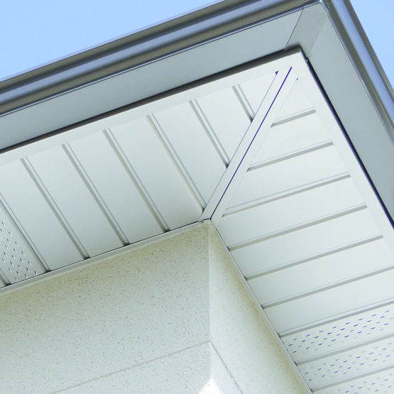 Dessous de toit en PVC, finition lisse, installé en angle avec rainures pour l'évacuation de l'eau.