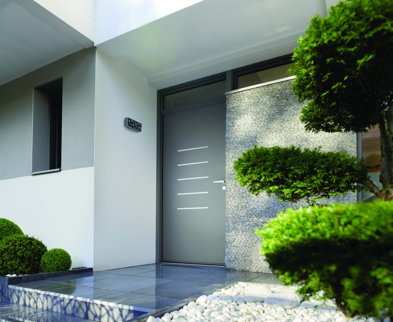 Porte en aluminium gris avec motifs en acier inoxydable.