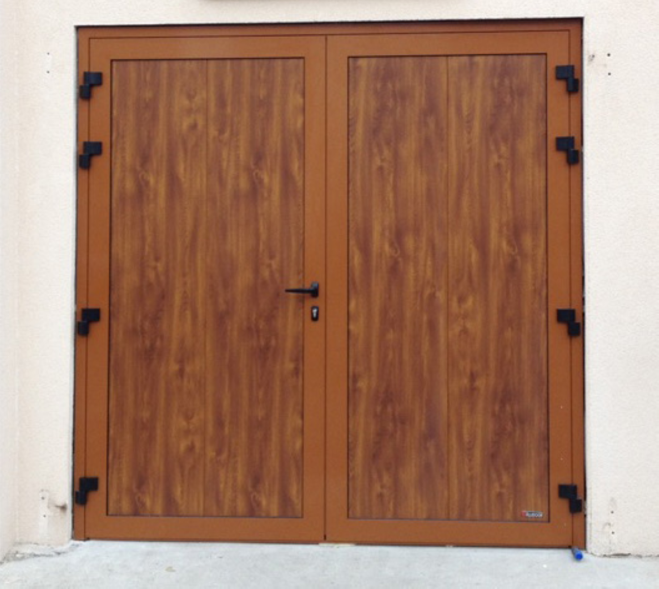 Porte de garage en bois composite avec finition effet bois et serrure, à double battant.