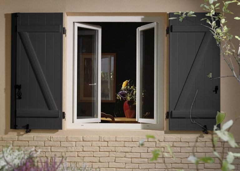 Volet battant en bois couleur gris, installé sur une fenêtre à ouverture à la française.