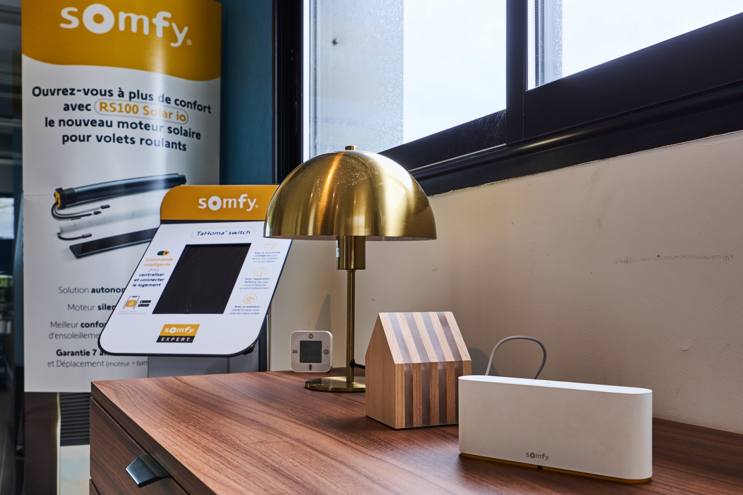 Système de contrôle pour volets roulants Somfy, incluant un moteur et un boîtier de commande.