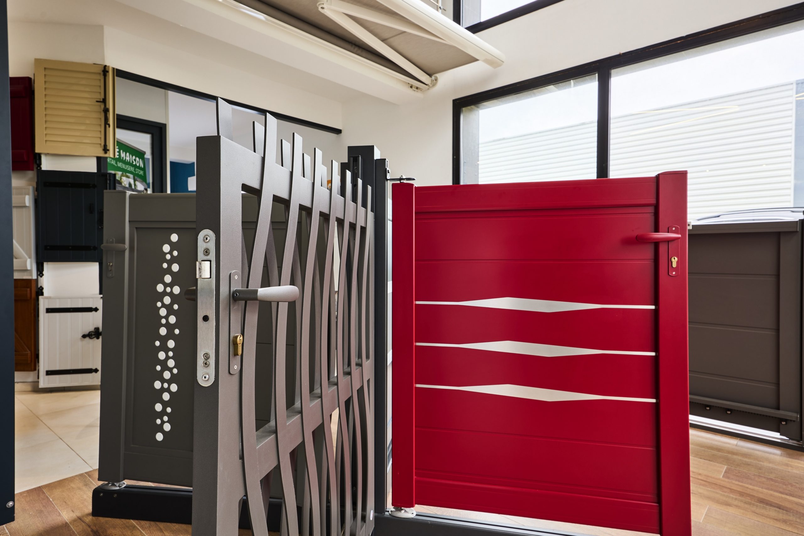 Portail en aluminium rouge avec motifs décoratifs et mécanisme de fermeture.