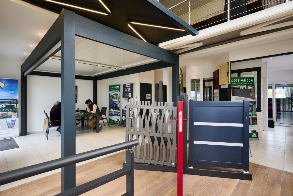 Portail coulissant en aluminium avec finition bleue et éléments décoratifs en acier.